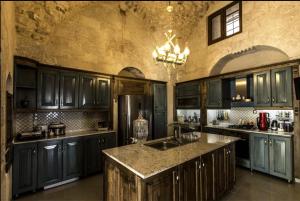 a kitchen with dark blue cabinets and a large island at Birsen Hanım Konağı in Mardin