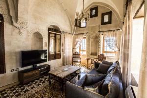 a living room with a couch and a tv at Birsen Hanım Konağı in Mardin