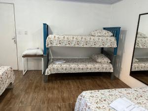 a room with three bunk beds and a mirror at Canto do viajante in São Gabriel