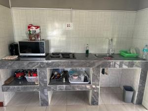 a kitchen with a counter with a sink and a microwave at Agreste Homes in Kasama +36 photos