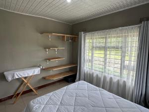 a bedroom with a bed and a window at Agreste Homes in Kasama