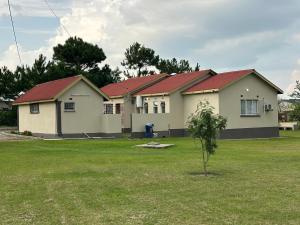 a row of houses with red roofs in a yard at Agreste Homes in Kasama