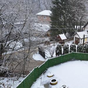 a snow covered yard with a green fence and snow at Vila Raj in Gornja Toplica +53 photos