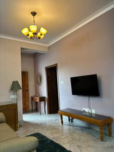 a living room with a couch and a tv on the wall at Villa Vista in Mysore