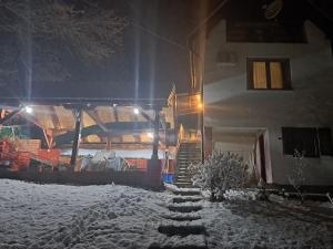 a house with snow on the ground next to a house at Vila Raj in Gornja Toplica