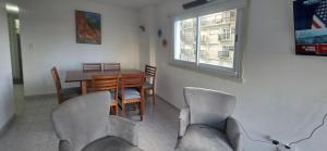 a dining room with a table and chairs and a window at EdenMDQ-4 in Mar del Plata +8 photos