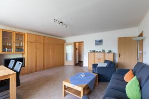 a living room with a blue couch and a table at Haus Luv und Lee Wohnung 26 in Döse