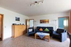 a living room with a couch and two chairs and a table at Haus Luv und Lee Wohnung 26 in Döse