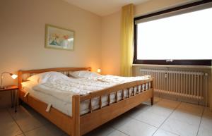 a bedroom with a bed and a large window at Haus Seehund, Whg 13 in Cuxhaven