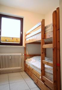 a bedroom with two bunk beds and a window at Haus Seehund, Whg 13 in Cuxhaven