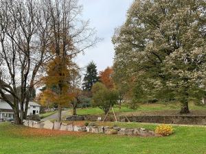 a park with trees and a stone wall and a playground at Gîte Théophile Fenal in Badonviller