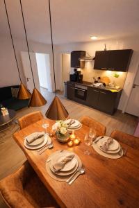 a wooden table with plates and glasses on it in a kitchen at La Suite Hotel - Self Check-in in Hanau am Main