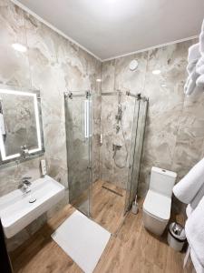 een badkamer met een douche, een toilet en een wastafel bij Джерело in Brody