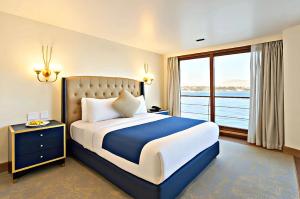 a bedroom with a large bed and a large window at Five-Star Deluxe River Kruz from Aswan to Luxor 3 Nights in Aswān +33 photos