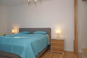 a bedroom with a bed and a night stand with two lamps at Haus Yachthafen, Whg 4 in Cuxhaven