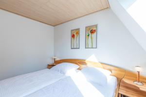 a bedroom with a bed and two paintings on the wall at Seegras in Cuxhaven