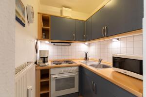 a kitchen with a sink and a stove at Haus Elbe 1, Whg 11 in Duhnen +4 photos