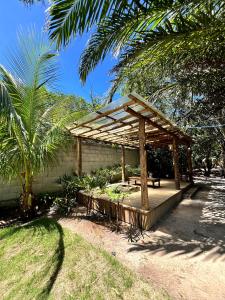 a wooden pergola with a picnic table in a yard at Sítio Araripe Eco House in Santa Cruz Cabrália