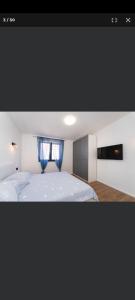 a bedroom with a bed and a window with blue curtains at Petra in Biograd na Moru +8 photos
