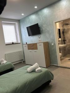 a room with two beds and a television on the wall at Aura Apartment 2 Herne in Herne