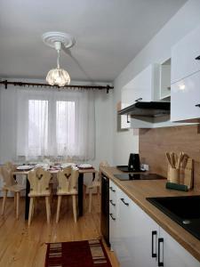 a kitchen and dining room with a table and chairs at Apartament Kułachówka - Sielskie wakacje na wsi, własny sad, pasieka i ogród in Leśnica