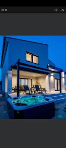 a house with a swimming pool in front of it at Petra in Biograd na Moru