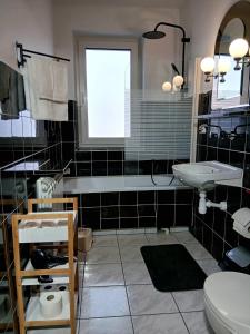 a black and white bathroom with a sink and a toilet at Apartament Kułachówka - Sielskie wakacje na wsi, własny sad, pasieka i ogród in Leśnica +10 photos