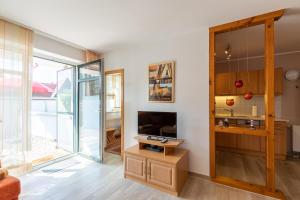 a living room with a tv and a sliding glass door at Haus Weser, Whg 2 in Döse