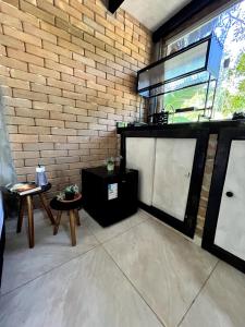 a living room with a brick wall and a table at Sítio Araripe Eco House in Santa Cruz Cabrália