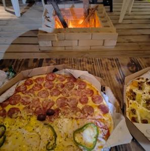 a pizza sitting on top of a table next to a fire at Sítio Araripe Eco House in Santa Cruz Cabrália +54 photos