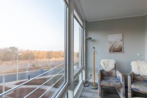 a room with two chairs and a large window at Kurpark Residenz, App 219b in Döse