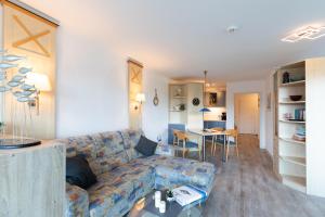 a living room with a couch and a table at Kurpark Residenz, App 219b in Döse