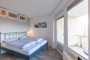 a bedroom with a bed and a sink and a window at Kurpark Residenz, App 219b in Döse