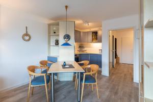 a kitchen and dining room with a table and chairs at Kurpark Residenz, App 219b in Döse +29 photos