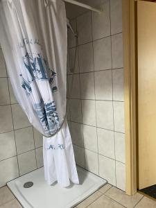 a shower curtain sitting on a stand in a bathroom at Apartment An der Büdnerei in Graal-Müritz +14 photos