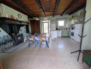 een keuken met een tafel en stoelen in een kamer bij Gîte en pierre maison quercynoise in Vaylats
