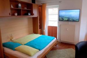 a bedroom with a bed with a television on the wall at Haus Elbe 1, Whg 18 in Cuxhaven