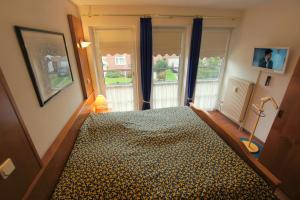 a bedroom with a bed in a room with windows at Haus Elbe 1, Whg 18 in Cuxhaven +8 photos