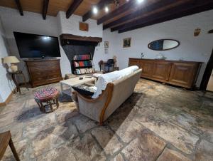 een woonkamer met een bank en een flatscreen-tv bij Gîte en pierre maison quercynoise in Vaylats