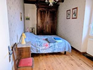 een slaapkamer met een bed en een houten vloer bij Gîte en pierre maison quercynoise in Vaylats