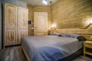 a bedroom with a large bed and a brick wall at Agriturismo La Collina in Pitigliano