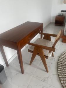 a wooden table and a chair and a table and a table at Villa Elina 09 in Badung
