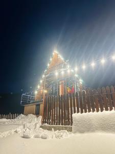 een huis met een hek in de sneeuw bij Mountain Shadow Cottage in Racha in Ghebi