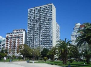 a tall building in a city with palm trees and buildings at EdenMDQ-4 in Mar del Plata