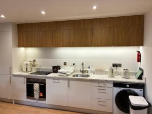 a kitchen with white cabinets and a sink at Clare Escape Ballycastle - Luxury town centre apartment, walk to beach & harbour, near Giants Causeway in Ballycastle