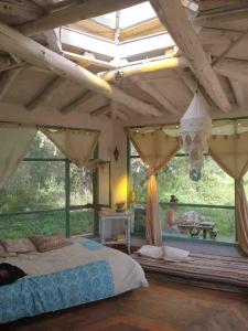 a bedroom with a large bed and a large window at Cosmika, eco casa de montaña in Las Calles