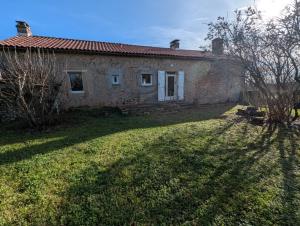 een oud stenen huis met een tuin ervoor bij Gîte en pierre maison quercynoise in Vaylats +3 foto's