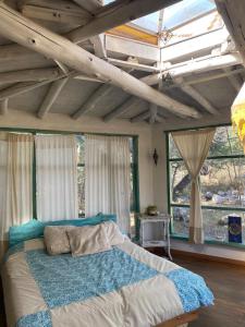a bedroom with a bed in a room with windows at Cosmika, eco casa de montaña in Las Calles