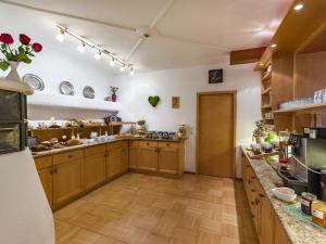een grote keuken met houten kasten en een aanrecht bij Gartenhotel Rosenhof bei Kitzbühel in Oberndorf in Tirol