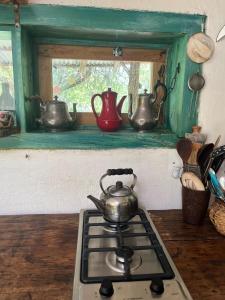 a stove top with tea pots on a window sill at Cosmika, eco casa de montaña in Las Calles